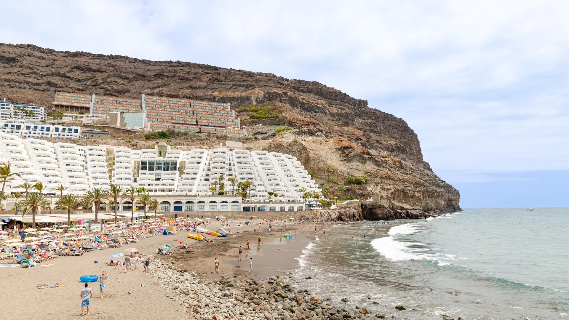 Tiered white resort hotels climbing the cliffs above the beach at Taurito, south-west Gran Canaria