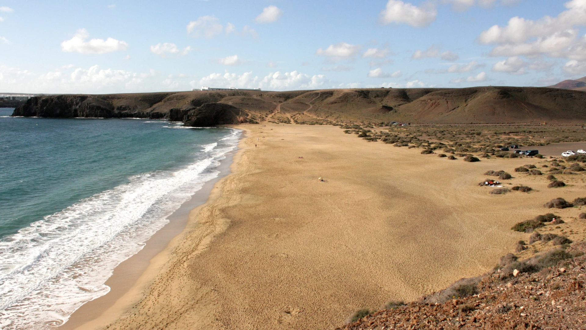 Playa Mujeres, a long beach of golden sand below low volcanic hills among the Papagayo coves in the Los Ajaches Natural Monument, Lanzarote