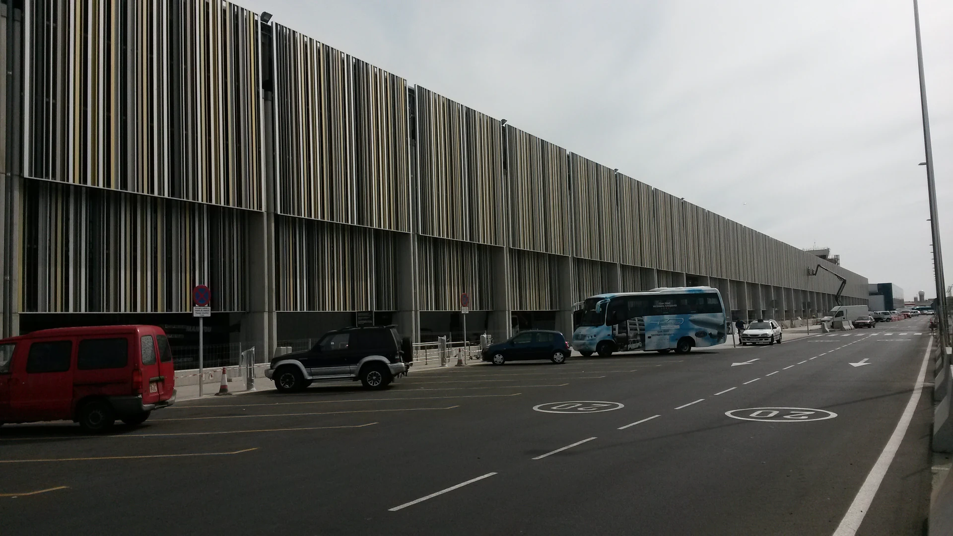 The terminal building and forecourt at Gran Canaria Airport, with a shuttle bus waiting at the kerb