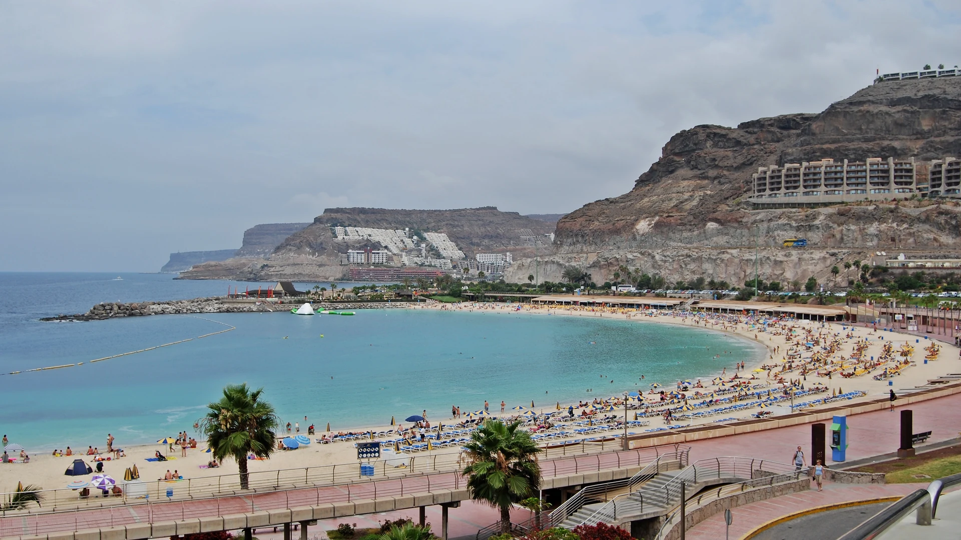 The sheltered crescent of Playa de Amadores with calm turquoise water, near Puerto Rico in south-west Gran Canaria