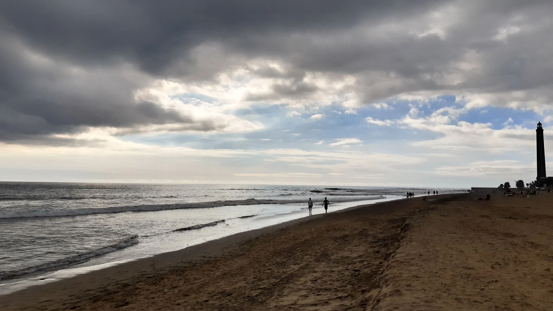 Cloud building over the beach at Maspalomas with the lighthouse in the distance, southern Gran Canaria