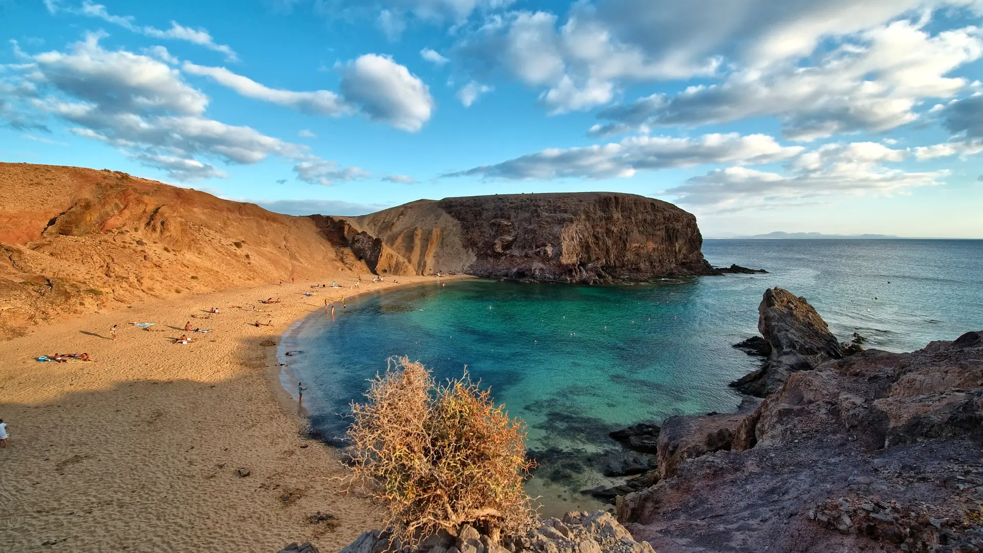 Playa de Papagayo, a sandy cove below volcanic cliffs on Lanzarote's southern tip, with turquoise water in the bay
