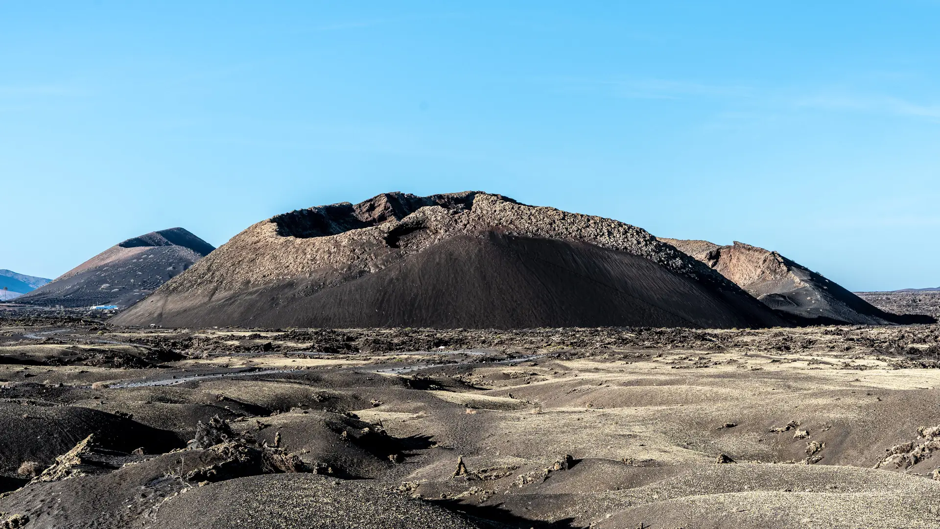 The cinder cone of Caldera de los Cuervos rising above a lava field in Los Volcanes Natural Park, Lanzarote