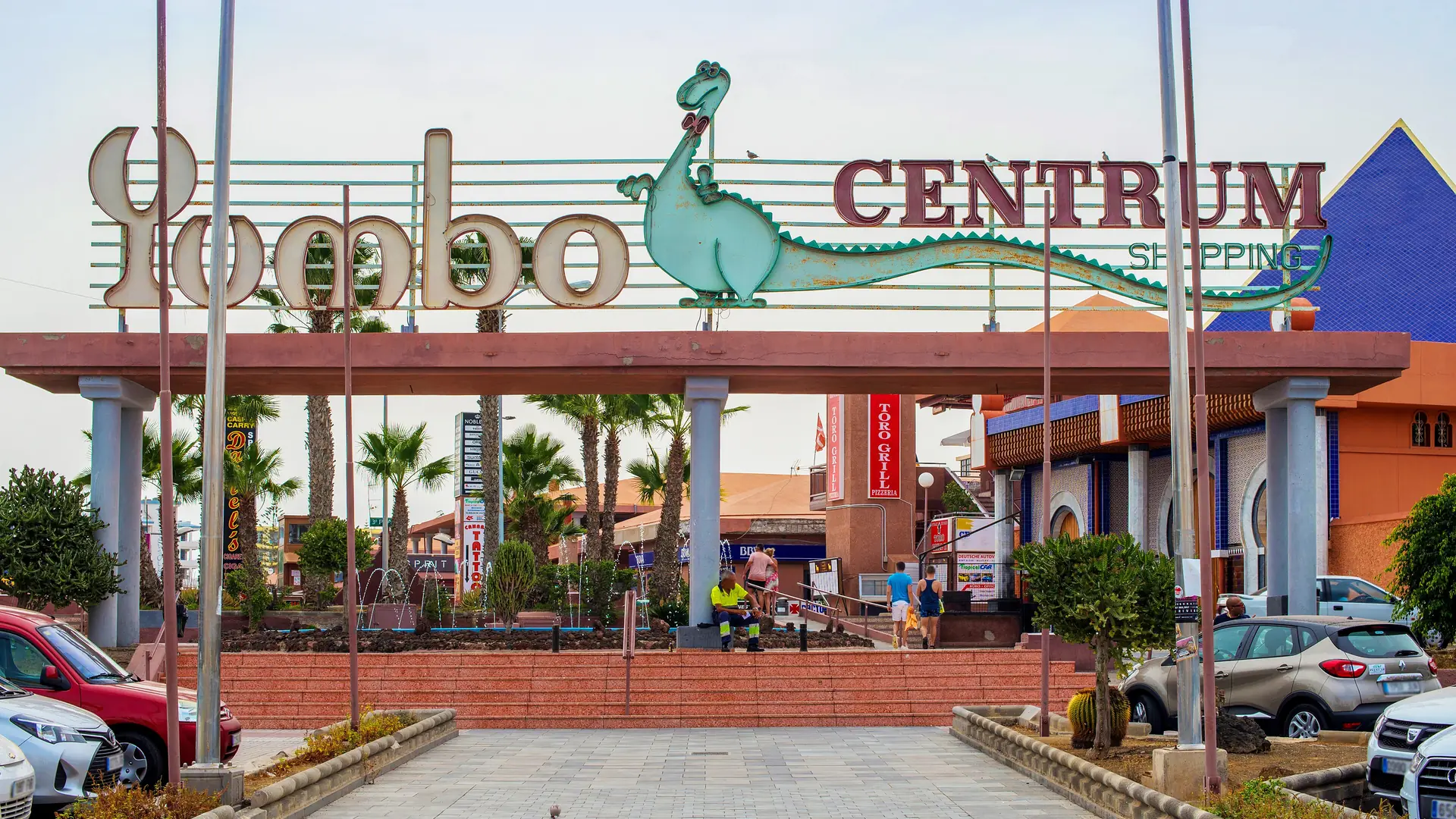 The entrance arch and dinosaur sign of the Yumbo Centrum shopping and nightlife centre in Playa del Inglés, Gran Canaria