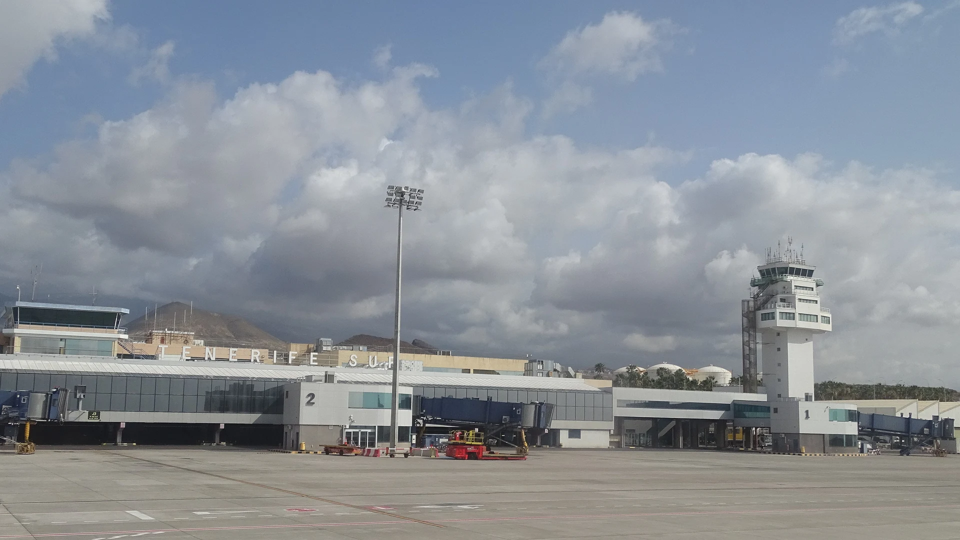 The terminal building and control tower at Tenerife South airport, with the arid hills of Granadilla de Abona behind
