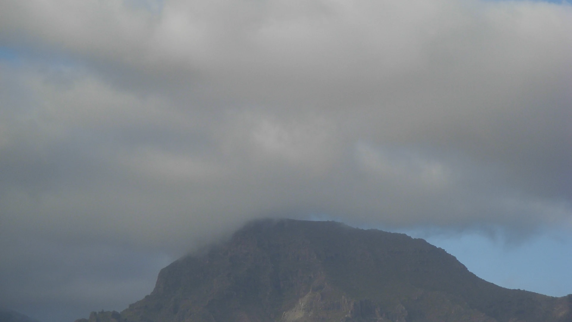 Cloud sitting against a mountain slope in Tenerife, formed by the trade winds