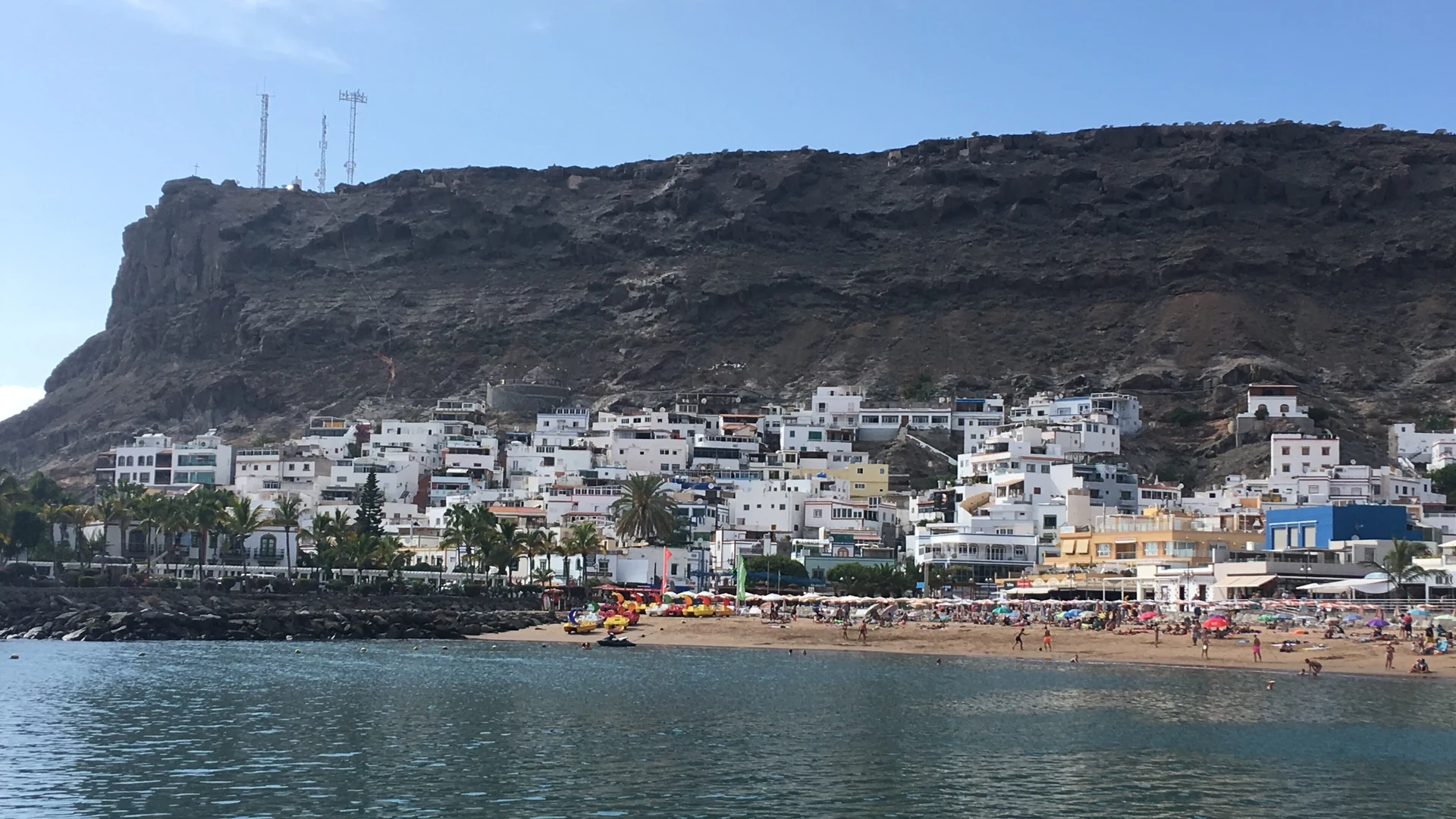 White apartment blocks stepping up the hillside behind the beach and harbour at Puerto de Mogán, south-west Gran Canaria