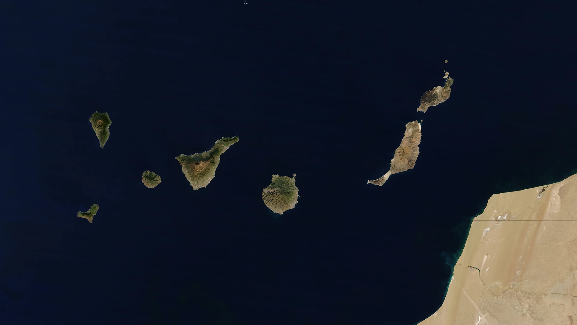 Satellite view of all seven main Canary Islands on a clear day, from El Hierro and La Palma in the west to Lanzarote and Fuerteventura beside the African coast